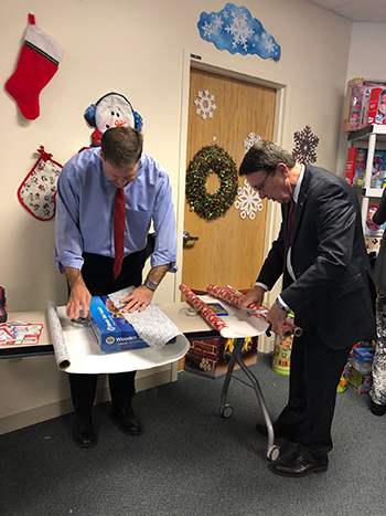 Governor Sununu and Demers wrapping gifts