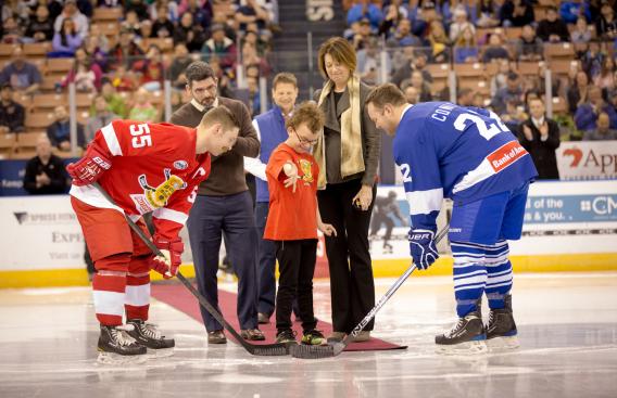 A child drops the puck to start a hockey game.