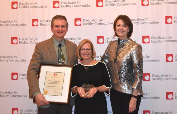 Group photo of award recipients: Chief Quality and Value Officer George Blike, MD; Director of Quality and Safety Lori Key, MBA, RN; and CEO and President Joanne Conroy, MD.