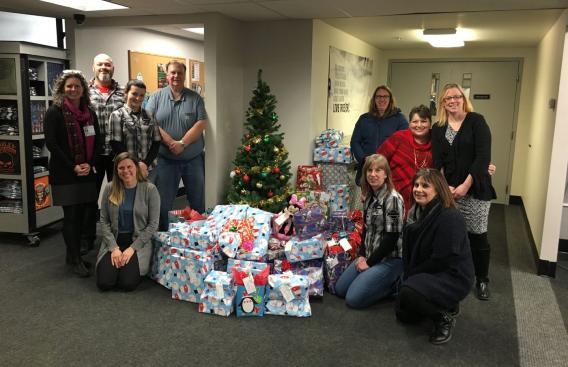Staff from Moms in Recovery, Twin State Harley Davidson, and the Upper Valley Harley Owners Group with a pile of presents.