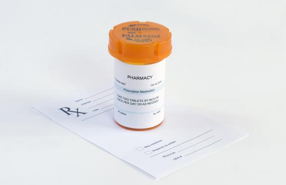 Prescription bottle on top of paper prescription.