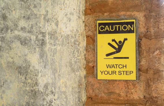 Sign with stick figure slipping on a wet surface.