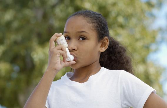 Young girl using an inhaler.