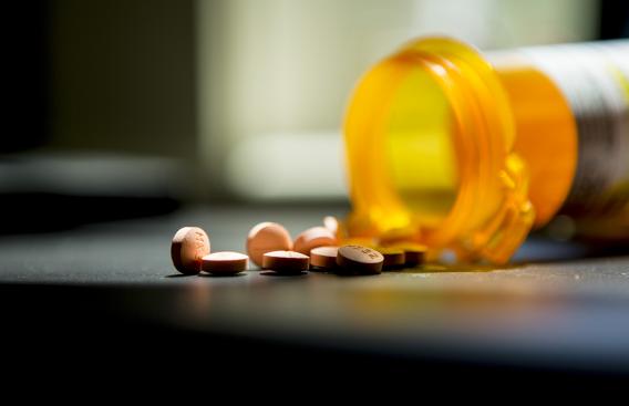 Pills spilling out of an opened pill bottle