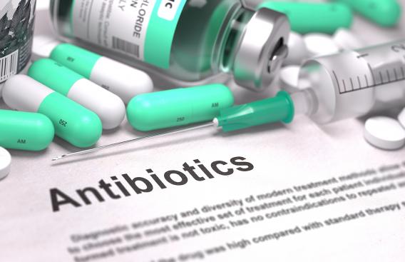 Antibiotic pills on top of a paper with an antibiotic description