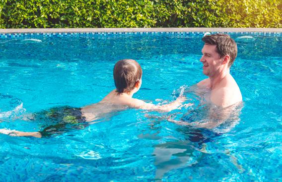 Father and son swimming in pool
