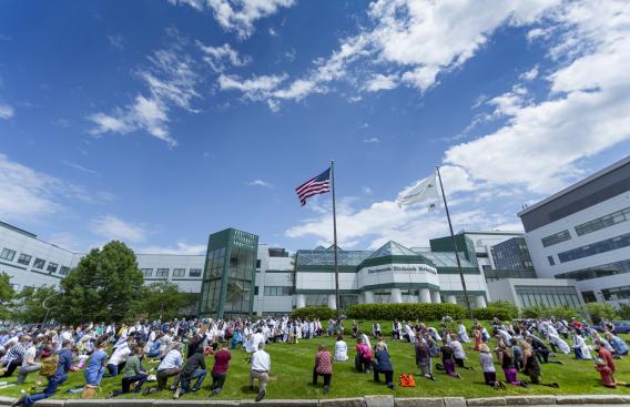 Outside photo of DHMC with providers kneeling