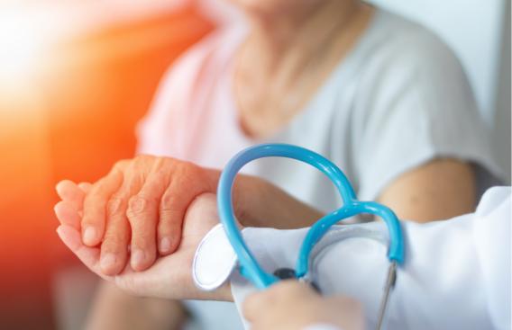 Doctor holding hands with elder patient.